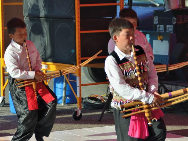 Three Hmong boys playing the qeej at the Little Mekong Night Market in St. Paul, Minnesota on August 7, 2015.