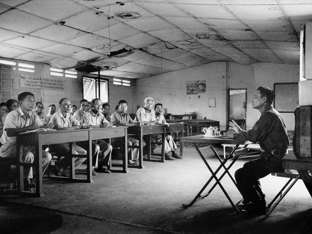 A political re-education class for Generals and senior military officers of the former South Vietnamese Army, a North Vietnamese Communist officer gives them political indoctrination classes as they sit quietly like schoolchildren. Second from left is one time Defense Minister, General Nguyễn Hữu Có. Có was imprisoned for 12 years, decided not to emigrate after being released and lived in Vietnam until his death in 2012.