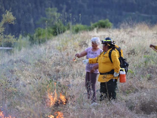 Wilverna Reece and Gina Saxon lighting fire to the land for cultural burns  in Karuk ancestral territory  © Karuk Tribe