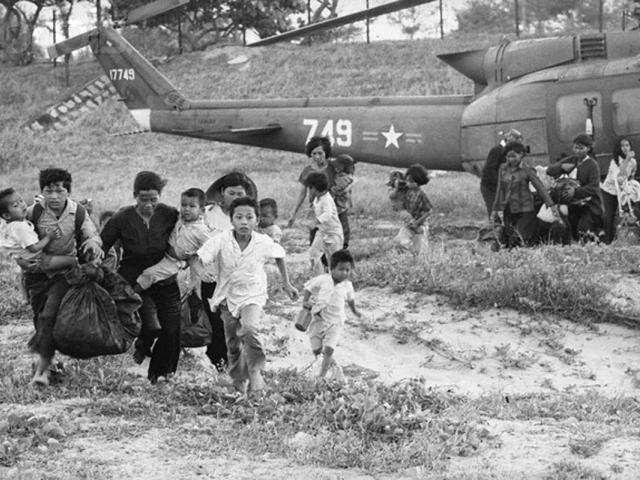 23 Mar 1975, Phu Bon, South Vietnam --- Phu Bon, South Vietnam: Refugees from the Central Highlands run for rescue helicopters to evacuate them to safety. The Communist gunners shot up the convoy of tears heading towards costal havens to the east, splitting it into segments. --- Image by © Bettmann/CORBIS