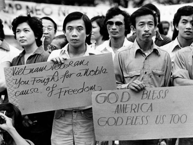 Vietnamese immigrants gather at Houston City Hall with signs for the ceremony of the sixth anniversary of the fall of South Vietnam, 1981.