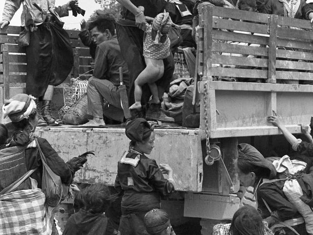 Hmong people climbing on to a truck in Ban Xon. Site: LS-272, Coordinates: TF 5994