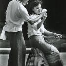 Two Long Beach high school students, Vong York (left) and Ra Chim portray a young couple engaging in playful flirtation in the final scene depicted in the popular folk dance Robam Nesat or “The Fishing Dance.” Ra Chim sits on the ang rut, the bell-shaped fishing trap used to catch larger fish in shallow waters, used by the young men in the dance. She holds the chhneang, braided bamboo baskets that act as strainers, used by young women in the dance. The scene depicts the couple’s courtship and falling in lov