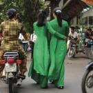 Women wearing green ao dais, traditional Vietnamese attire.