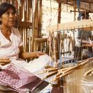 Silk production and weaving are an important part of Cambodian cultural heritage as well as a source income for many Cambodian families, especially in rural areas of Cambodia. Textiles are produced using various regional designs and traditional motifs for scarves (krama), traditional clothing, and decorative fabrics. In this photo, a Cambodian woman is working at a wooden weaving loom in Cambodia. (Photo courtesy of Bonnie Lowenthal)