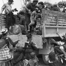 Hmong people climbing on to a truck in Ban Xon. Site: LS-272, Coordinates: TF 5994